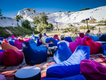 Rainbow beanbags looking onto Pamukkale. It looks like a sky slope!