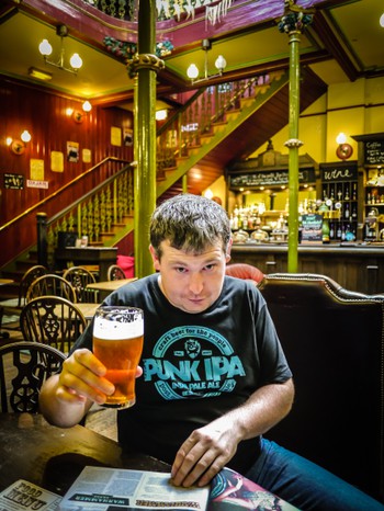 Matt reading important business news in the paper while having a nice ale